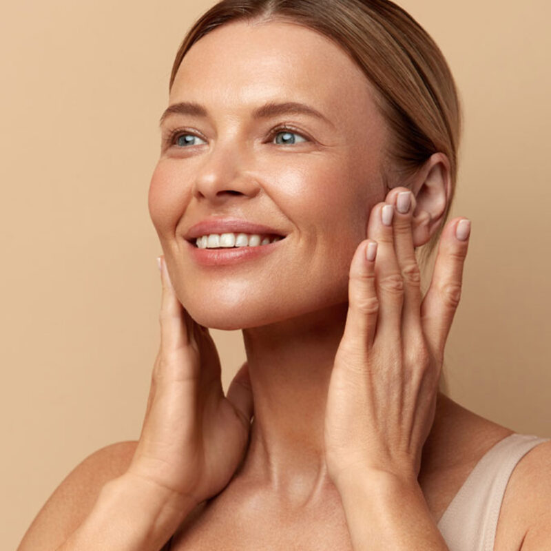 Frau berührt ihr glattes Gesicht nach einer Botox®-Behandlung